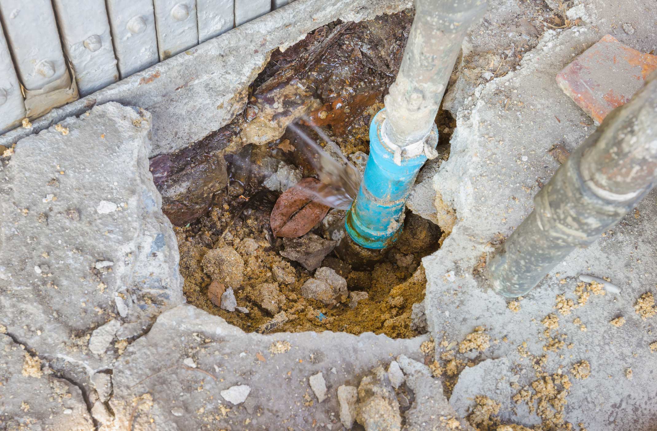 dreamstime_m_67622282 Water leaks from underground blue pipes.